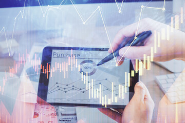 Double exposure of man's hands holding and using a phone and financial chart drawing. Market analysis concept.
