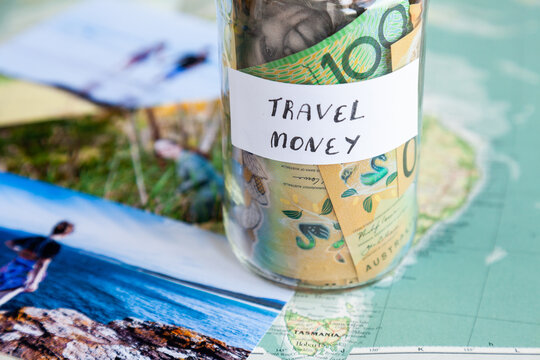 Travel in Australia to coastal destination concept - money in jar on map with holiday photos