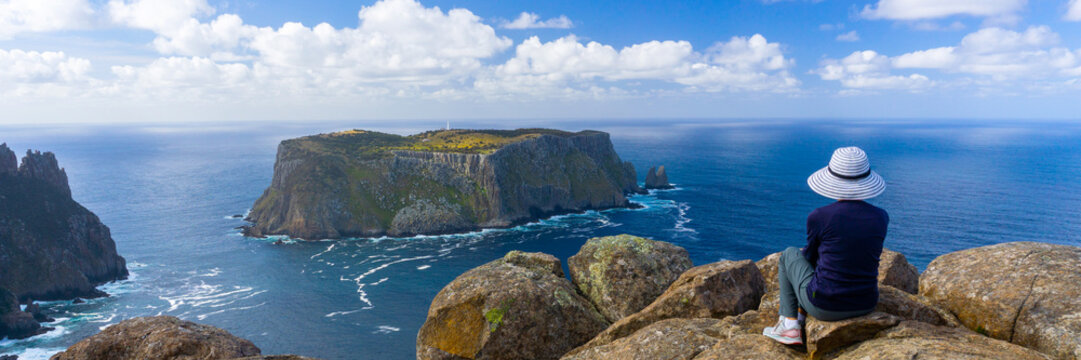Woman in hat looking at Tasman Island