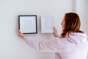 Woman holds a wooden frame with empty space. Mockup concept.