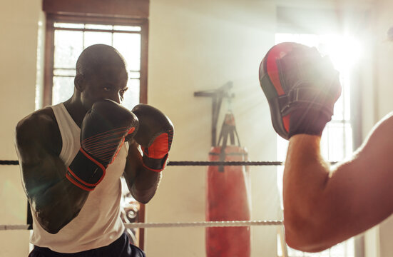 Focused boxer facing a punching mitt