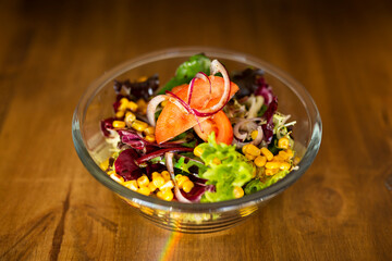 Green salad in a big bowl on a wooden table
