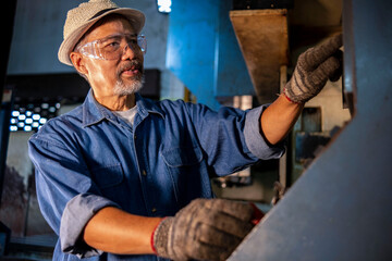 Turner worker working on drill bit in a workshop business with old Asian machines in China.