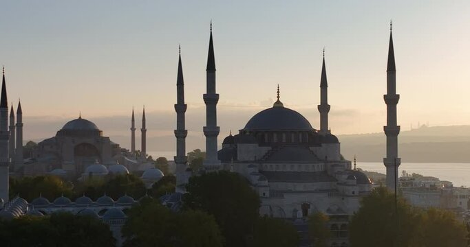 Istanbul, Turkey. Sultanahmet with the Blue Mosque and the Hagia Sophia with a Golden Horn on the background at sunrise. Cinematic Aerial view.