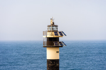 Fototapeta na wymiar black and withe lighthouse with solar panels