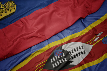 waving colorful flag of swaziland and national flag of liechtenstein.