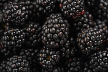 a heap of fresh ripe blackberries in a black plate