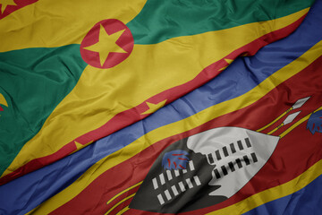 waving colorful flag of swaziland and national flag of grenada.