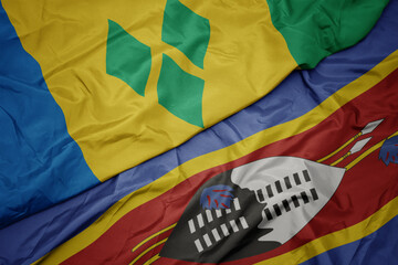 waving colorful flag of swaziland and national flag of saint vincent and the grenadines.