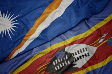 waving colorful flag of swaziland and national flag of Marshall Islands .