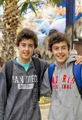 happy twins smiling at camera in the sea park , san diego california