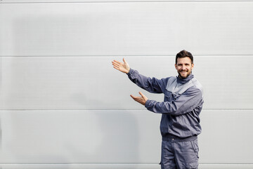 A worker shows at the blank space and smiles at the camera.