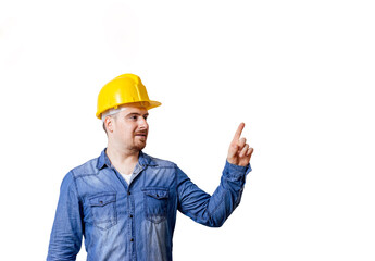 Young man with safety helmet is pointing to a copy space.