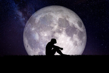Fototapeta na wymiar man sitting in prayer with the moon in the background