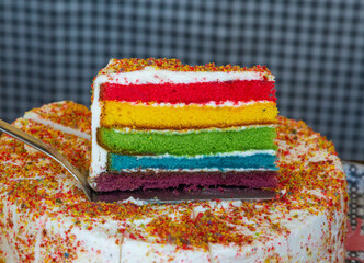 A close up of a gay pride cake with delicious layers of sponge and fondant icing