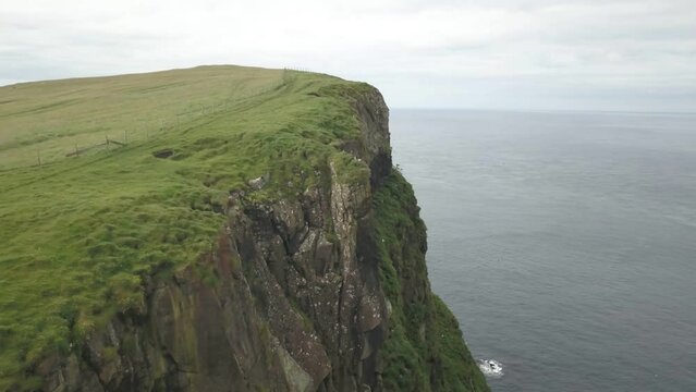 Green cliffs of Faroe islands in cloudy weather