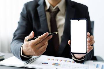 Business man holding a mobile phone or smartphone showing a workspace blank screen.