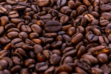 Coffee beans background. Grão de café. Fullframe shot of fresh roastend coffee beans zoom in. Aromatic brown textured seeds on background from close up. Black energy structured grain on backdrop. 