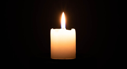 Candel flame. Candles Burning at Night. White Candles Burning in the Dark with focus on single candle in foreground.