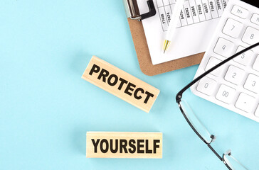 PROTECT YOURSELF text written on wooden block with clipboard,eye glasses and calculator Business concept.