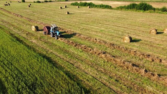 Tractor bailing dry grass in countryside
