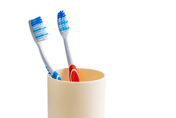 View of new toothbrushes red and blue handle in plastic cup isolated on white background with clipping path.