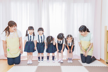 Obraz premium 発表会の練習をする子どもたちと保育士