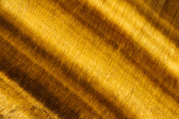 Tiger's eye golden macro detail texture background. close-up polished semi-precious gemstone.