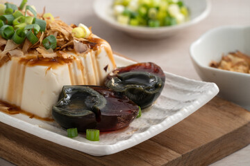 Delicious Chilled tofu and century egg with soy sauce and bonito flakes.