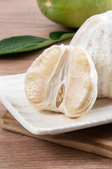 Fresh pomelo fruit on wooden table background.