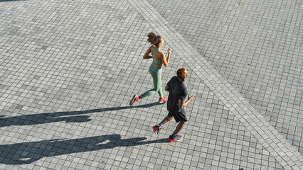 Top of black sports couple run on empty city area