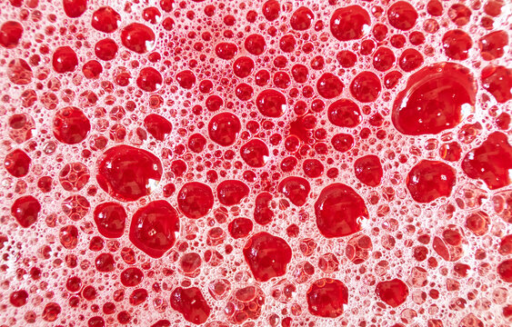 Abstract structure of red foamed surface of liquid. Low-depth background image.