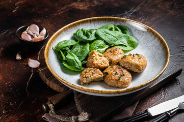  Fish Cakes or Fish balls with tuna and spinach in a plate. Dark background. Top view