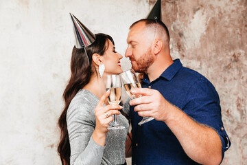 Funny man and woman with hats on their heads ,a festive party with champagne lifestyle party. the couple celebrates a birthday or new year.