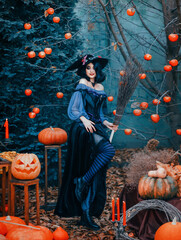 Portrait fantasy happy woman witch sexy posing. Orange pumpkin for halloween holiday decor scenery....