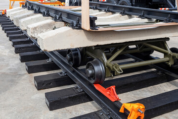 Rail laying equipment. Trolley with concrete sleepers on rails. Concept of emergency repair of railways. Equipment for restoration of railway tracks. Process of installing concrete sleepers