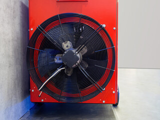 Ventilation equipment. Air conditioner fan close-up. Conditioning with split technology. Red metal block with fan. Ventilation equipment near concrete wall. Climate control. Indoor air ventilation