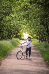 Fototapeta premium A woman with a bike on a road in the park