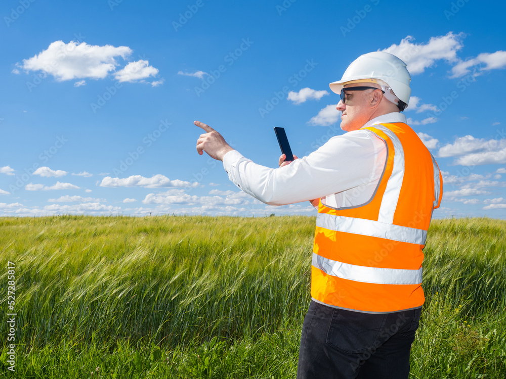 Aufkleber builder on green field. choosing place for building. man in builder uniform and helmet. builder poin