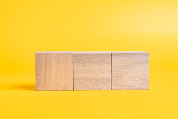 Three wooden cubes on yellow background, Editable, Static object