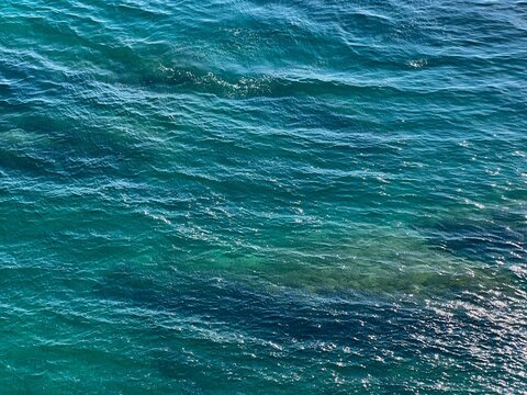 Turquoise blue sea glittering waves background.
