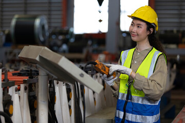 woman factory worker or engineer operating remote switch to control machine in the factory