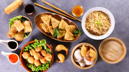 assorted of asian food ( samossa, fried noddles, spring rool,, fried shrimp and soy sauce )