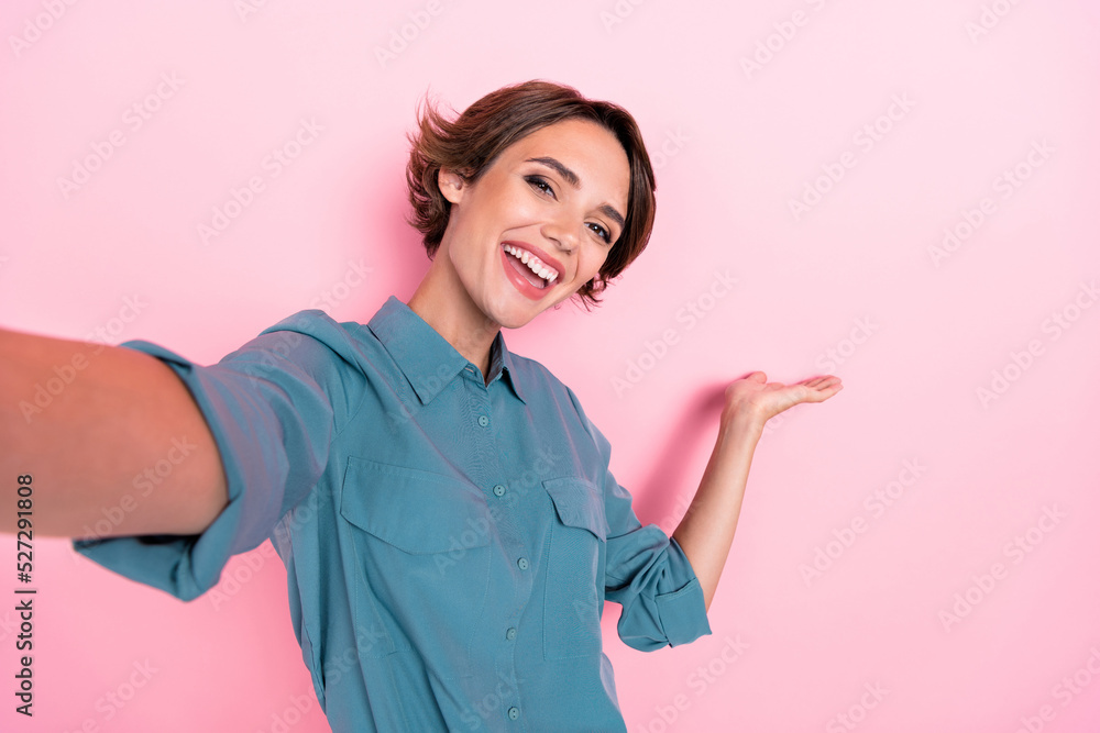 Wall mural photo of charming positive lady take selfie arm hold demonstrate empty space isolated on pink color 