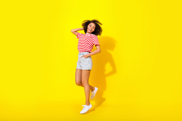 Fototapeta na wymiar Full size photo of cool lady wear red t-shirt shorts boots isolated on vivid yellow color background