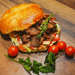delicious pita with cherry tomatoes and beef rosemary and mint 
lies on a wooden board