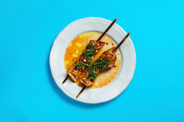 Squid on a skewer with iceberg lettuce shavings and chopped chili