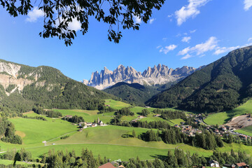 The idyllic St. Magdalena village with magical Dolomites mountain peaks Odle Group at the background in Funes valley, South Tyrol, Italian Alps