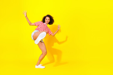 Fototapeta na wymiar Full size photo of young attractive funny girl dancing new shoes absolutely clean isolated on yellow color background