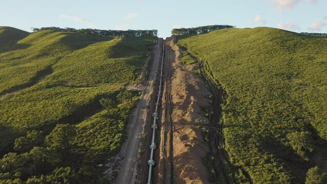 Laying the main gas pipe in a dug trench among the mountains